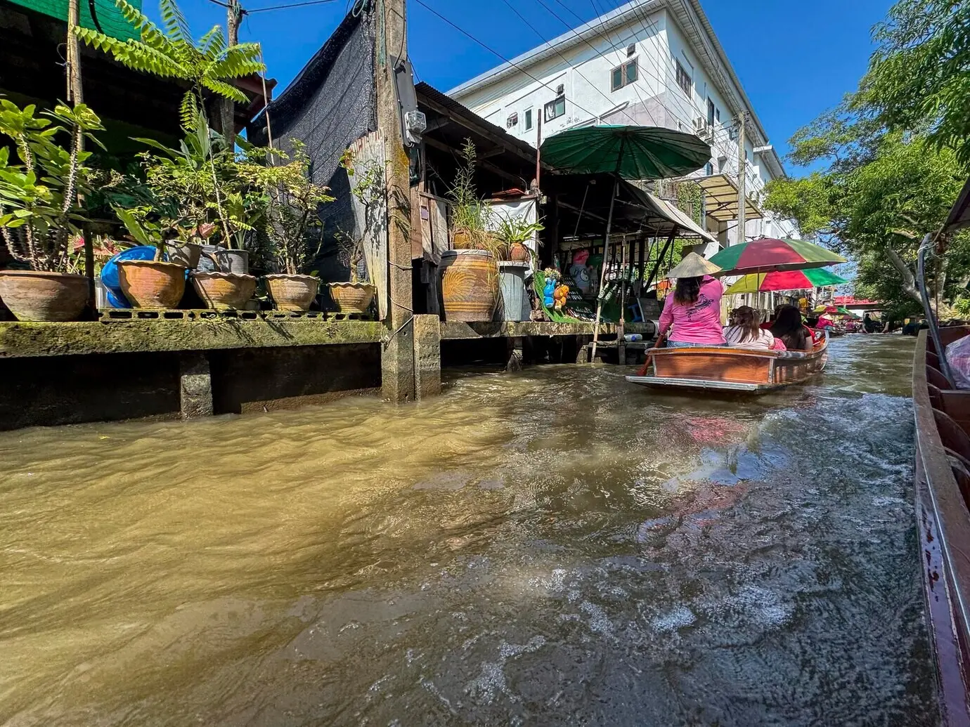 Bangkok, Thailand, 12. November 2024: Menschen besuchen den schwimmenden Markt für Erzeugnisse.